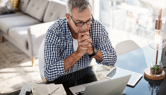 man looking at laptop screen pensively